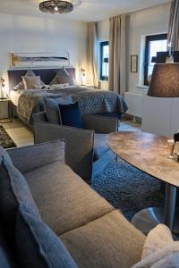 um quarto com uma cama, um sofá e uma mesa em Ferienwohnung SCHMUCKSTERN em Flensburg