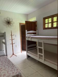 een slaapkamer met 2 stapelbedden en een raam bij Casa Amarela na praia para 13 pessoas in Ilhéus