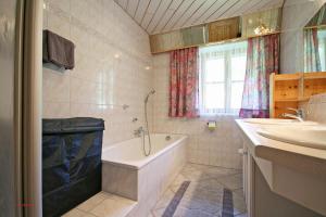y baño con bañera y lavamanos. en Almliesl LOFE-460, en Sankt Martin bei Lofer