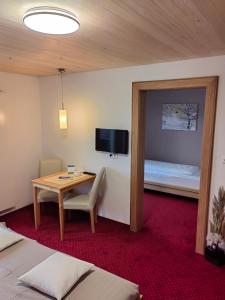 una camera d'albergo con tavolo e letto di Frühstückspension Bilgeri a Sulzberg