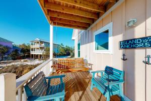 twee blauwe banken op de veranda van een gebouw bij Island Anchors in Gulf Shores