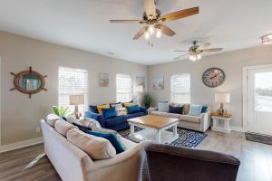 a living room with couches and a ceiling fan at Island Anchors in Gulf Shores