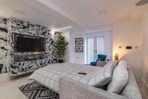 a bedroom with a bed and a couch and a tv at Garden Apartment West Bridgford in Nottingham