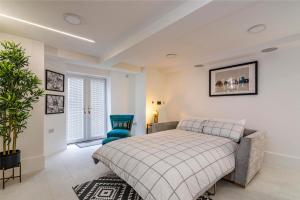 a bedroom with a bed and a blue chair at Garden Apartment West Bridgford in Nottingham