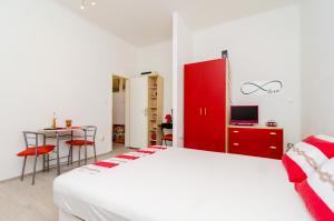 a bedroom with a white bed and a red cabinet at Apartment Caceris in Dubrovnik