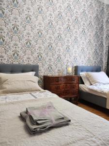 ein Schlafzimmer mit einem Bett und einer Kommode mit Handtüchern darauf in der Unterkunft Villa Art deco in Dębica