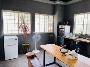a kitchen with a table and a refrigerator and a fan at 太麻里金崙線織屋背包房Line Weaving House B&B in Taimali