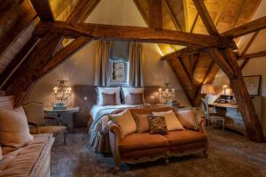 een slaapkamer met een bed en een bank in een kamer bij Kasteel van Ordingen in Sint-Truiden