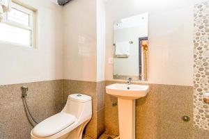 a bathroom with a toilet and a sink at Octave Kings Suites in Bangalore