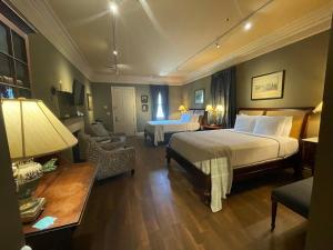 a hotel room with two beds and a living room at The Inn at Houmas House Estate in Darrow