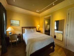 a bedroom with a bed and a desk and a chair at The Inn at Houmas House Estate in Darrow