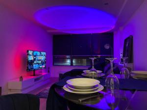 a purple room with a table and a tv at Perfect for Families & Business - Demha Nights in Birmingham