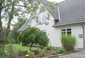 a white house with a garden in front of it at Ferienwohnung Schadwill in Simonsberg