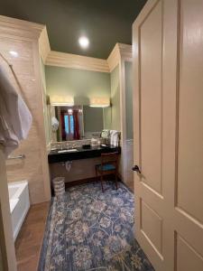 a bathroom with a sink and a tub and a mirror at The Inn at Houmas House Estate in Darrow