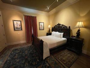 a bedroom with a large bed and a red curtain at The Inn at Houmas House Estate in Darrow