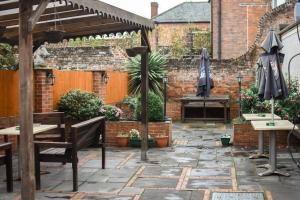 a patio with tables and umbrellas and a brick wall at The Crown and Woolpack in Long Sutton