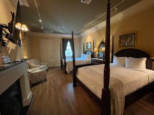 a hotel room with two beds and a fireplace at The Inn at Houmas House Estate in Darrow
