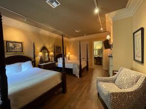 a hotel room with two beds and a chair at The Inn at Houmas House Estate in Darrow