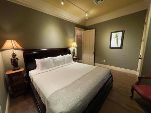 a bedroom with a large bed and a red chair at The Inn at Houmas House Estate in Darrow