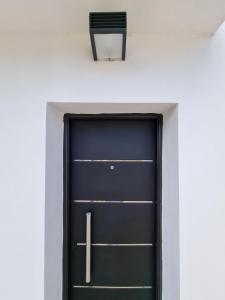 uma porta preta numa parede branca com uma cadeira preta em Departamento en el centro de la ciudad em Mercedes