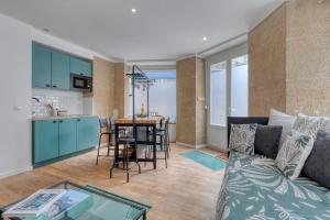 a living room and kitchen with a couch and a table at Les Vignes de Montmartre in Paris