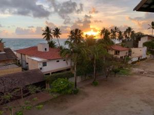 a group of houses and palm trees in front of the ocean at Solar Porto Rico in Porto De Galinhas