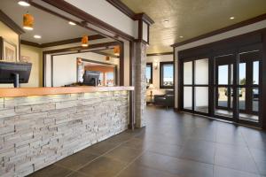 a lobby with a bar with a stone wall at Days Inn by Wyndham High Level in High Level