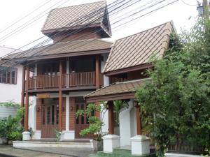 a house with a balcony and a roof at Baanlek Home Stay in Chiang Mai