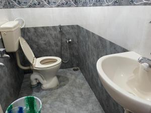a bathroom with a toilet and a sink at Sarah Residency in Thanjāvūr