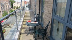 a small table on the balcony of a house at Citystay - The Vie in Cambridge