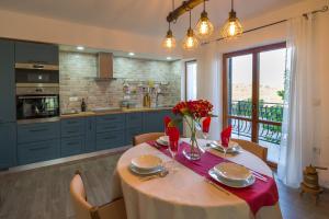 - une cuisine avec une table ornée de fleurs rouges dans l'établissement Motovun Bellevue - amazing view, comfortable, à Livade