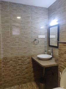a bathroom with a sink and a mirror at Areia De Goa, Comfort Stay Apartment near Baga Beach in Baga