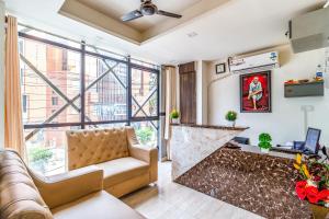 Una sala de estar con un sofá y una ventana grande. en Octave Kings Suites, en Bangalore