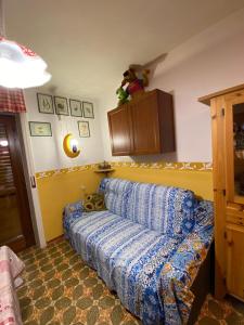 un soggiorno con divano blu in una camera di Bilocale condominio del sole a San Giacomo