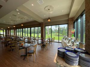 a restaurant with tables and chairs and large windows at The Inn at Houmas House Estate in Darrow