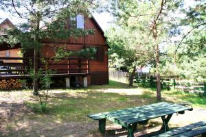 a picnic table in front of a wooden house at Summer House Stare Jabłonki in Stare Jabłonki