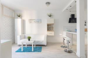Biały salon z białą kanapą i stołem w obiekcie Rondo ONZ Business Apartment w Warszawie +26 zdjęć