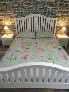 a bedroom with a white bed with pink flowers on it at Aпартамент 5 in Varna City