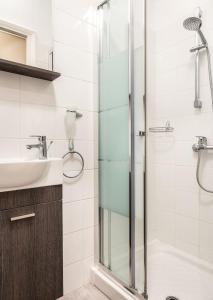 Un baño con ducha de cristal y lavabo. en Unlock Athens from sunny studio near Acropolis, en Atenas 13 fotos más