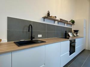 a kitchen with white cabinets and a sink at Direkter Moselblick 126m² großer Altbau und Terrasse in Sankt Aldegund