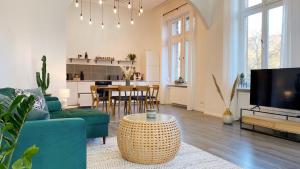 ein Wohnzimmer mit einem blauen Sofa und einem Tisch in der Unterkunft Direkter Moselblick 126m² großer Altbau und Terrasse in Sankt Aldegund