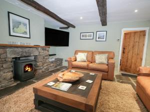a living room with a couch and a fireplace at Green Stile Cottage in Windermere