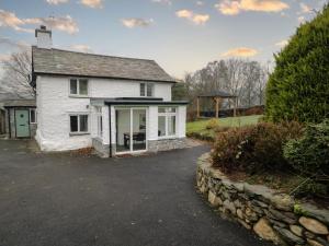 a white house with a driveway in front of it at Green Stile Cottage in Windermere