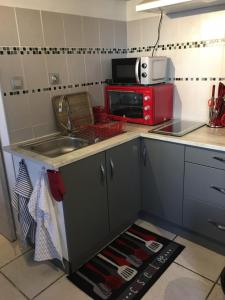 eine Küche mit einer Spüle und einer Mikrowelle in der Unterkunft Le Welcome in Coutras