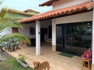 a brown dog standing in front of a house at Hostel Suite Home in Saquarema