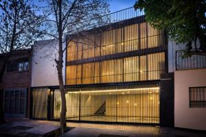 a building with a large window with lights on it at Escala83 Apartamentos in Mendoza