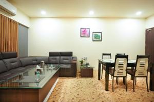a living room with a couch and a table and chairs at Sayaji Lodging in Gārgoti