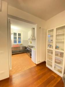 a kitchen with white cabinets and a wooden floor at Villa Arancia Quiet, Central, Parking and Air Conditioning in Levanto