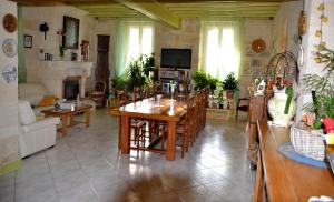 a large living room with a table and chairs at Maison d'Hôtes La Prévôté in Périssac