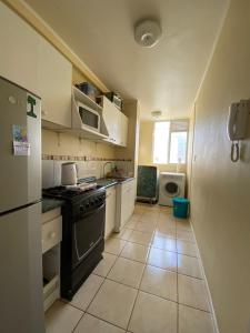 eine kleine Küche mit einem Herd und einem Kühlschrank in der Unterkunft Departamento Mar in La Serena